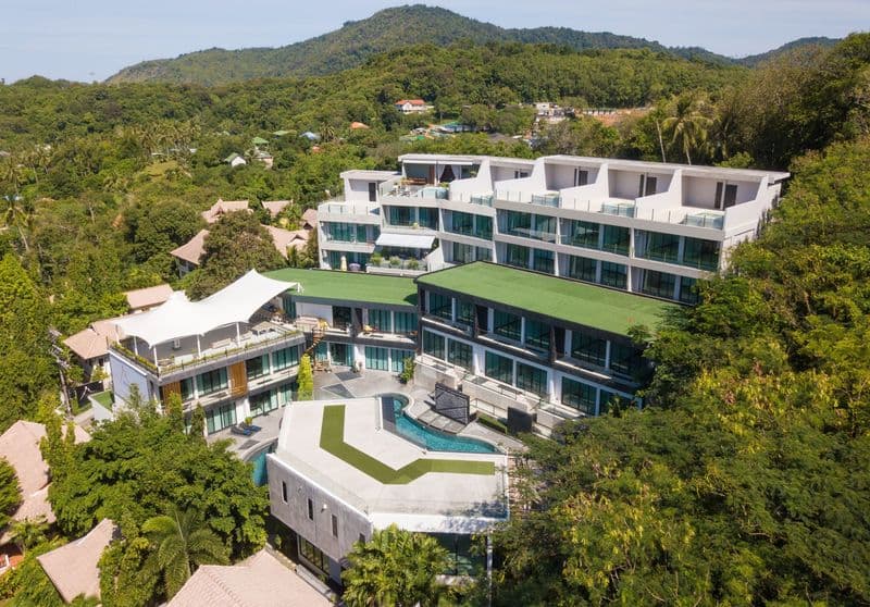 Aerial view of a hillside condominium with a pool in Rawai, Phuket